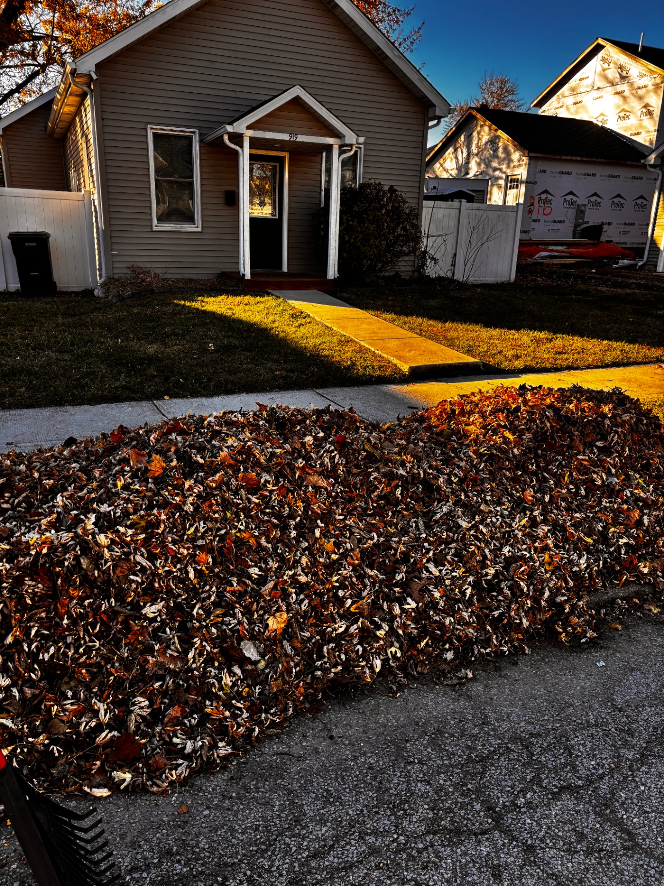 Fall leaf cleanup with leaves piled curbside at a South Bend home