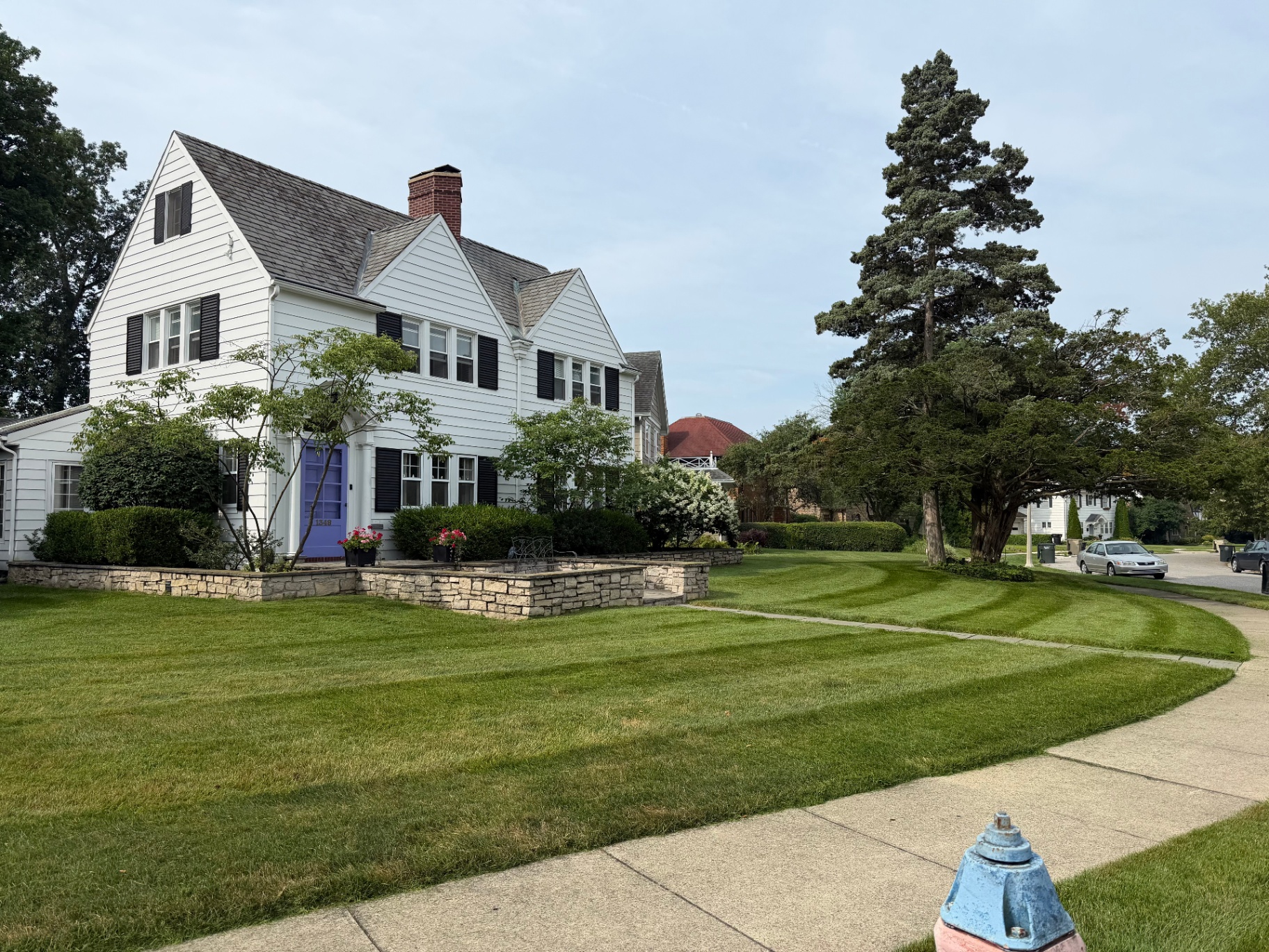 Manicured, freshly striped residential lawn with stone planting beds